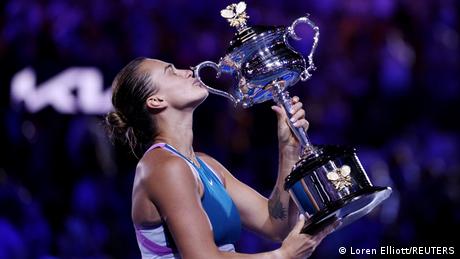 Tennisspielerin Aryna Sabalenka küsst nach dem gewonnenen Finale der Australian Open den Siegerpokal