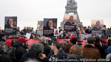 People hold portraits of French hostages in Iran Cecile Kohler, left, and Benjamin Briere during a protest in Paris, Saturday, Jan. 28, 2023. Families and friends of a growing number of Europeans imprisoned in Iran gathered in Paris on Saturday to call for their release. The banner reads : Freedom for state hostages in Iran. (AP Photo/Thibault Camus)