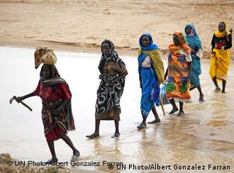 African women crossing a stream