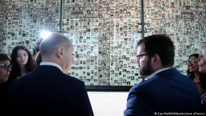 Scholz y Boric se miran frente a un memorial con víctimas de la dictadura militar.