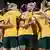 Members of the Australia team celebrate a goal in a huddle, image from an April 12, 2022 friendly against New Zealand.