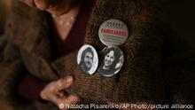 In this Oct. 25, 2016 photo, Angela Lita Boitano, president of Human Rights organization Families of the Disappeared and Detained for Political Reasons, shows two pins on her sweater featuring her son Miguel Angel Boitano and daughter Adrian Silvia Boitano, both of whom disappeared during dirty war, in Buenos Aires, Argentina. The Vatican and Argentina's bishops have finished cataloguing their archives from the country's dirty war and will soon make them available to victims and their relatives who have long accused church members of complicity with the military dictatorship. (AP Photo/Natacha Pisarenko)