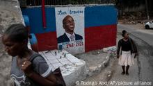 Women walk next to a mural with the portrait of the assassinated president of Haiti Jovenel Moïse in Port-au-Prince, Haiti, Wednesday, Sept. 22, 2021. (AP Photo/Rodrigo Abd)