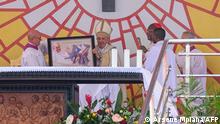 Pope Francis (2nd L) exchanges gifts with Cardinal Fridolin Ambongo Besungu (3rd R) during the papal mass at the N'Dolo Airport in Kinshasa, Democratic Republic of Congo (DRC), on February 1, 2023. (Photo by Arsene Mpiana / AFP)
