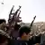 Libyan rebels fire in the air during a mass funeral in Ajdabiya, eastern Libya