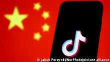 TikTok logo displayed on a phone screen and Chinese flag displayed on a screen in the background are seen in this illustration photo taken in Krakow, Poland on January 30, 2023. (Photo by Jakub Porzycki/NurPhoto)