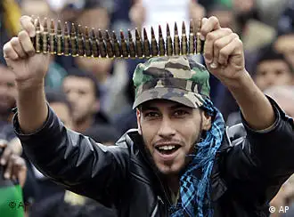 Anti-Libyan Leader Moammar Gadhafi protester, holds up bullets during a protest after Friday prayer at the court square, in Benghazi, eastern Libya, Friday March 4, 2011