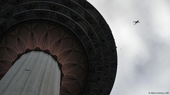 Base jumper jumping from the Kuala Lumpur Tower, seen from below