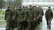 A group of new Bundeswehr recruits march in the rain, with an officer standing to their left, on the right side of the shot. A group of new Bundeswehr recruits march in the rain, with an officer standing to their left, on the right side of the shot.