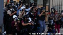 Journalists cover clashes between police and anti-government protesters in Lima, Peru, Tuesday, Jan. 24, 2023. Protesters are seeking the resignation of President Dina Boluarte, the release from prison of ousted President Pedro Castillo, immediate elections and justice for demonstrators killed in clashes with police. (AP Photo/Martin Mejia)