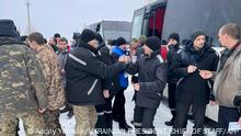 This handout picture taken and released by Ukrainian Presidential Chief of Staff Andriy Yermak on February 4, 2023, shows freed Ukrainian prisoners reacting following their exchange in an unknown location in Ukraine. (Photo by Ukrainian Presidential Chief of Staff Andriy Yermak / AFP)