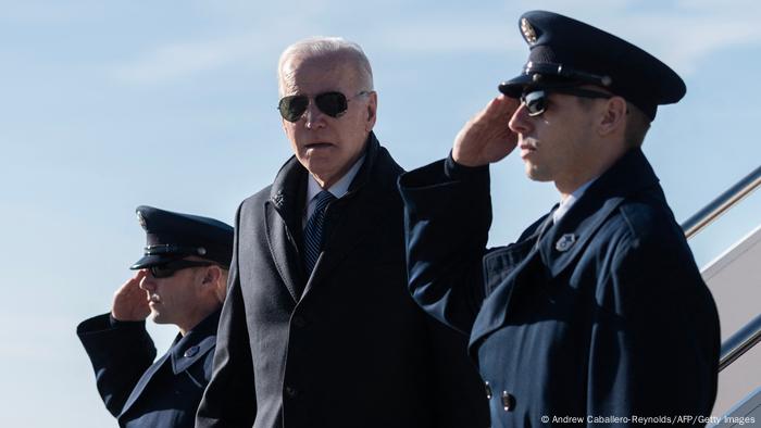 El presidente de los Estados Unidos, Joe Biden, flanqueado por dos militares que saludan