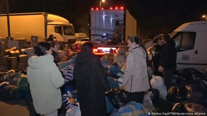 Helfer packen in Gelsenkirchen Säcke und Kisten mit warmer Kleidung in einen Lastwagen