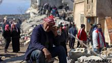地震发生后，一名叙利亚男子坐在叛军控制的金代里斯镇，倒塌建筑的废墟上哭泣。