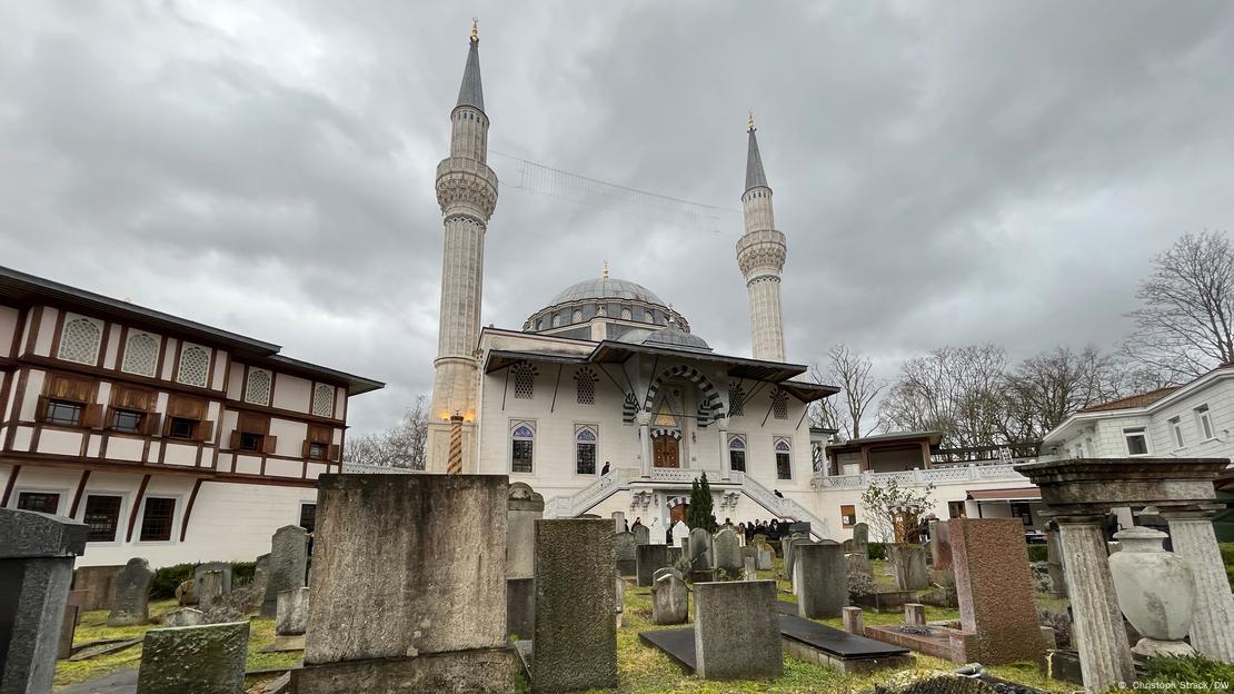Sehitlik Mosque and graves below a cloudy sky
