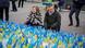German Defense Minister Boris Pistorius kneels, looking at a large number of small Ukrainian flags arranged together on a Kyiv street. German Defense Minister Boris Pistorius kneels, looking at a large number of small Ukrainian flags arranged together on a Kyiv street.