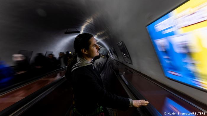 Ein Mann steht auf einer Rolltreppe einer Metro.