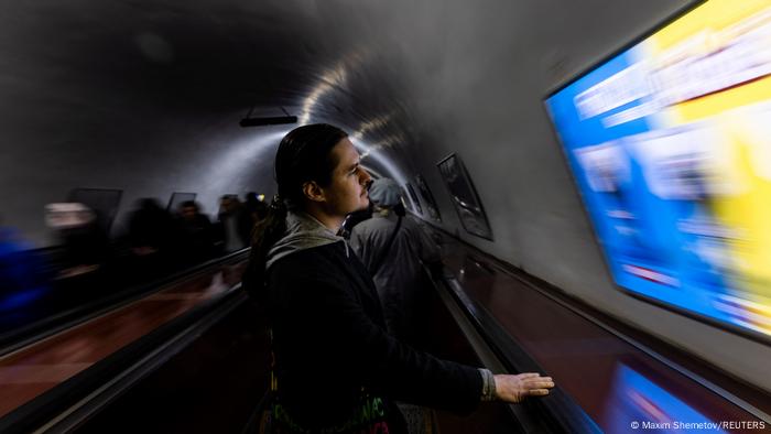 Ein Mann steht auf einer Rolltreppe einer Metro.