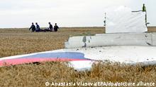 ARCHIV - 19.07.2014, Ukraine, Donezk: Einsatzkräfte transportieren eine Trage mit einem Leichensack durch ein Getreidefeld an der Absturzstelle der Boeing 777, die als Flug MH17 der Malaysia Airlines, beim Überfliegen der Ukraine, etwa 100 km östlich von Donezk, abstürzte. Der russische Präsident Putin spielte nach Erkenntnissen internationaler Ermittler eine aktive Rolle beim Abschuss des Passagierflugzeuges MH17 im Juli 2014 über der Ostukraine. Das geht aus abgehörten Telefongesprächen hervor, wie das Ermittlerteam am Mittwoch in Den Haag mitteilte. Foto: Anastasia Vlasova/EPA/dpa +++ dpa-Bildfunk +++