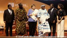 Former German Chancellor Angela Merkel, center, receives the Felix Houphouet Boigny price in Yamoussoukro, Ivory Coast, Wednesday Feb. 8, 2023. Merkel has been honored with the UNESCO peace prize for her efforts to allow more than 1.2 million migrants between 2015-2016 into Germany. (AP Photo/Diomande Ble Blonde)