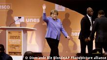 Former German Chancellor Angela Merkel waves before receiving the Felix Houphouet Boigny price in Yamoussoukro, Ivory Coast, Wednesday Feb. 8, 2023. Merkel has been honored with the UNESCO peace prize for her efforts to allow more than 1.2 million migrants between 2015-2016 into Germany. (AP Photo/Diomande Ble Blonde)