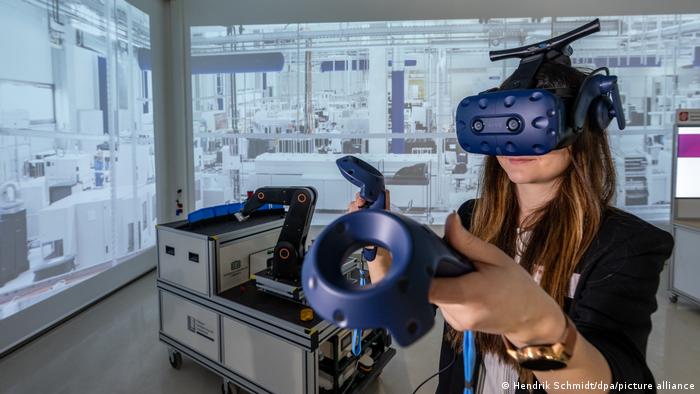 Символичное изображение I нехватка квалифицированных работников ИТ-индустрии. Женщина демонстрирует использование технологии виртуальной реальности при планировании производства на экспериментальной и цифровой фабрике в Хемницком университете.