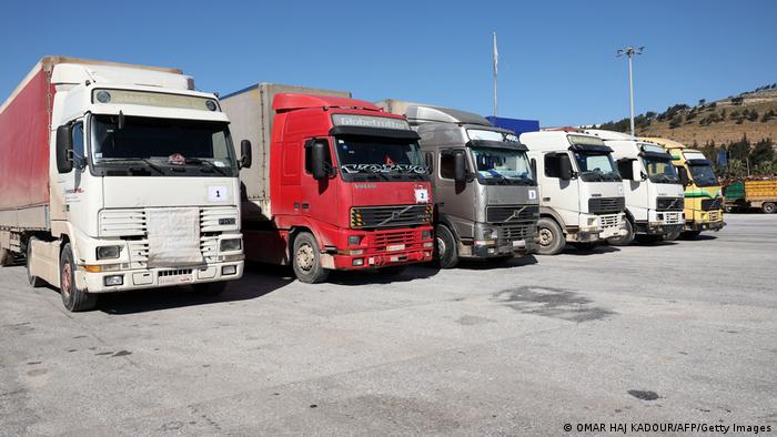 Sechs LKW stehen nebeneinander auf einem Platz an der türkisch-syrischen Grenze