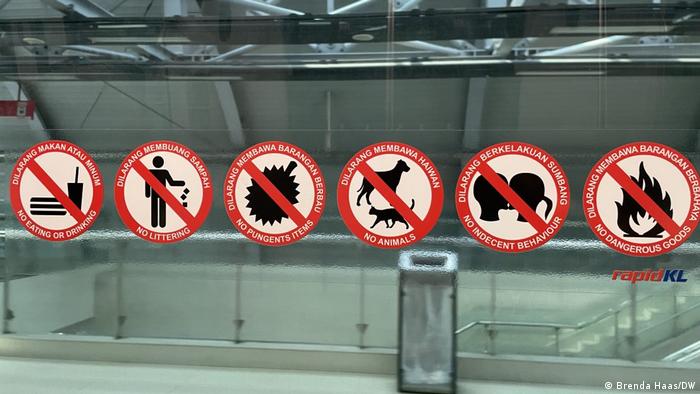 Verbotsschilder an einer malaysischen Bahnstation.