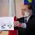 Silvio Berlusconi hält ein Papier mit einer Grafik hoch (Foto: AP)