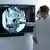 Médicos de máscara examinam tomografia em tela de tv na parede