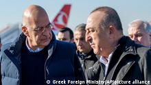 In this photo provided by the Greek Foreign Ministry, Greece's Foreign Minister Nikos Dendias, left, listens his Turkish counterpart, Mevlut Cavusoglu upon his arrival in Adana, southeastern Turkey, Sunday, Feb. 12, 2023. The visit was part of a new round of so-called earthquake diplomacy between the two uneasy allies, whose relations have often been frosty, if not downright hostile. (Greek Foreign Ministry via AP)