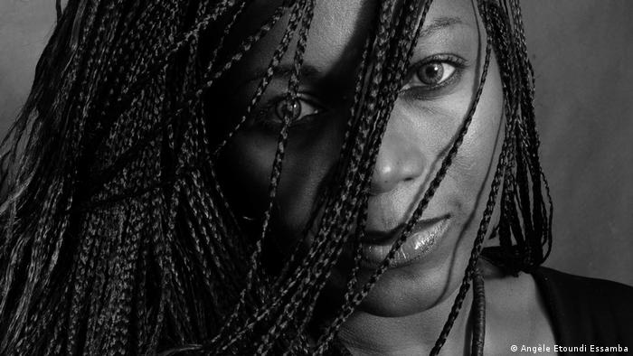 Schwarz-Weiß-Foto der Fotografin Angèle Etoundi Essamba mit Haaren vor dem Gesicht.