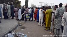People queue early in the day to withdraw money from cash dispensers that is crippled by cash shortages at a bank in Kano, northwest Nigeria, on February 8, 2023. - Africa's most populous country has been crippled by fuel shortages for weeks, and cash dispensers are running empty after a sudden currency swap two weeks ahead of Nigeria's presidential election. (Photo by PIUS UTOMI EKPEI / AFP)