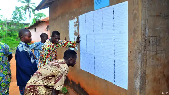 Wähler suchen ihren Namen auf den Wählerlisten vor den Wahllokalen in Benin (Foto: AP)