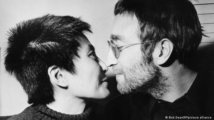 John Lennon und Yoko Ono geben sich einen Nasenkuss. Sie haben kurzgeschnittene Haare.