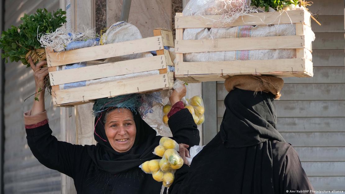 امرأة تحمل صندوقا مليئا بالخضار ومواد غذائية في القاهرة 25.01.2023
