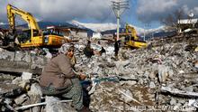 A woman sits amidst rubble and damages following an earthquake in Gaziantep, Turkey, February 7, 2023. REUTERS/Suhaib Salem
