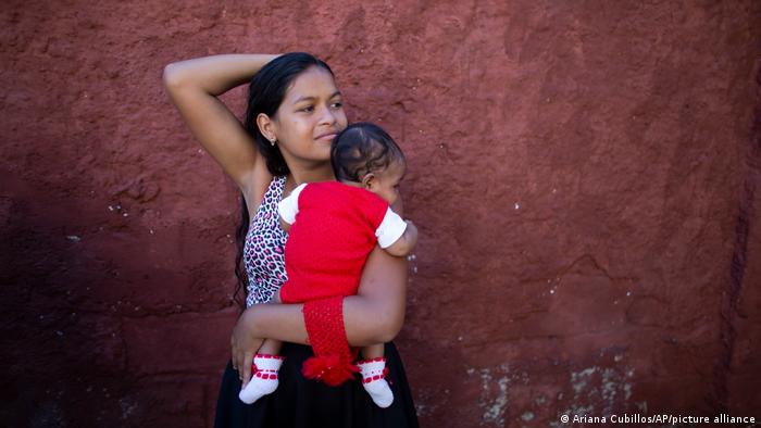 Una adolescente venezolana carga a su bebé en las afueras de Caracas. 