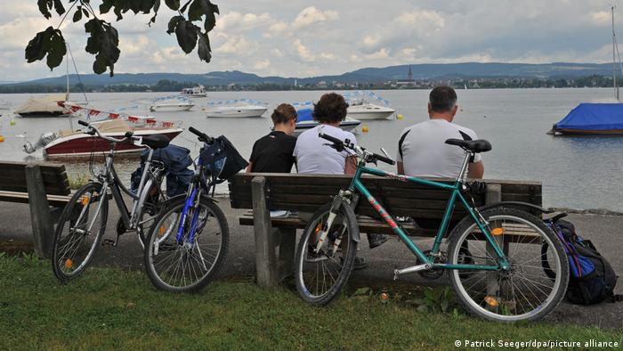Bicycle tourists rest at the port of Iznang on Lake Constance after a bike ride.