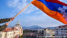 ARCHIV 25/12/2022 (FILES) In this file photo taken on December 25, 2022 a protester holds a flag of the self-proclaimed Nagorno-Karabakh (Flag of Artsakh) region during a rally in Stepanakert, capital of the self-proclaimed Nagorno-Karabakh region of Azerbaijan. - Authorities in the breakaway region of Nagorno-Karabakh shut schools on January 20, 2023 due to gas and electricity shortages amid a blockade by arch-enemy Azerbaijan. Since mid-December, a group of Azerbaijanis has been blocking a road to Karabakh to protest what they claim is illegal mining causing environmental damage in Karabakh. As a result, the region of around 120,000 people is running short of food, medicines and fuel. (Photo by Davit GHAHRAMANYAN / AFP)