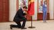 Moldovan Prime Minister Dorin Recean kneels down in front of a state flag as President Maia Sandu stands nearby during an inauguration ceremony in Chisinau, Moldova Moldovan Prime Minister Dorin Recean kneels down in front of a state flag as President Maia Sandu stands nearby during an inauguration ceremony in Chisinau, Moldova