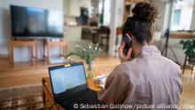 Eine Frau nimmt aufgrund der Ausbreitung des Coronaviruses aus ihrem Wohnzimmer an einer Telefonkonferenz teil. (zu dpa Mehr Stromverbrauch durchs Homeoffice - Debatte um EEG-Umlage) +++ dpa-Bildfunk +++
---
Raus aus den eigenen vier Wänden: Was lockt uns zurück ins Büro?