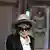 Yoko Ono, woman with a hat peers over her sunglasses