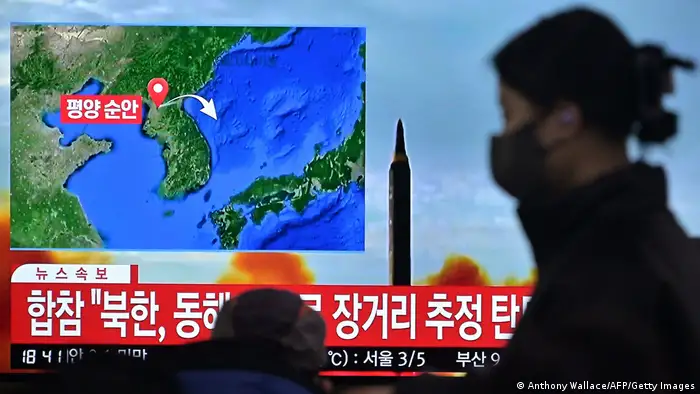 18日朝鮮試射導彈後，一名女子走過南韓報導此事的電視牆新聞畫面