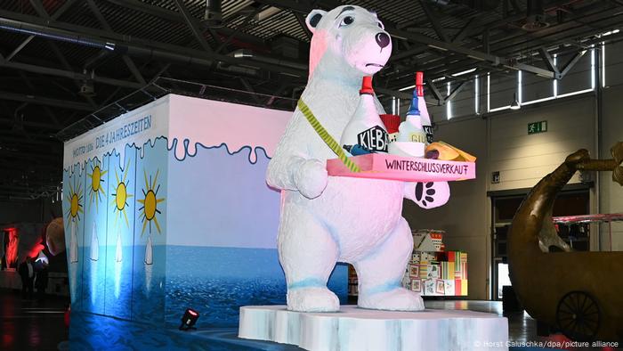 Un oso polar ofrece en bandeja adhesivos sobre el cambio climático en liquidación, una visión satírica de las acciones contra el calentamiento global.