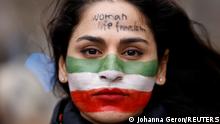 A woman, with her face painted in the colors of Iran's flag, takes part in a protest by Iranian community members to show solidarity with Iranian people, in Brussels, Belgium, February 20, 2023. REUTERS/Johanna Geron