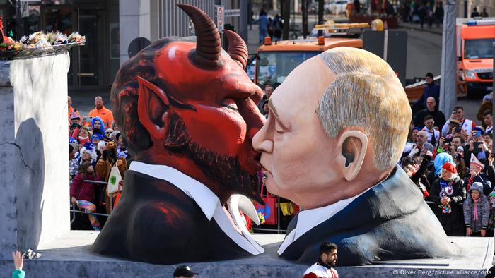 Putin y el demonio se besan: figuras de una carroza del carnaval de Colonia, Alemania.