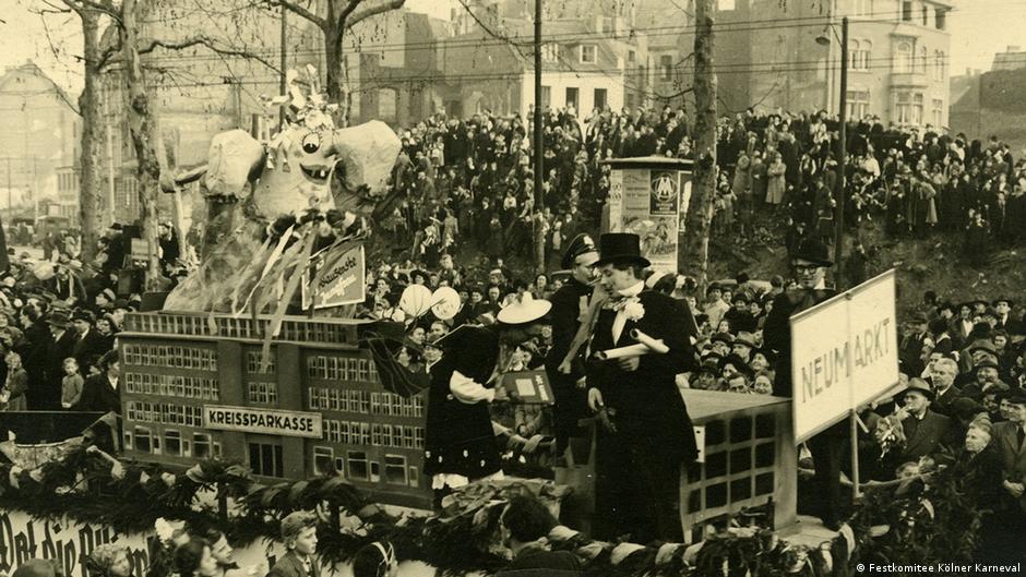 Eine historische Aufnahme zeigt das Karnevalstreiben auf den Straßen.