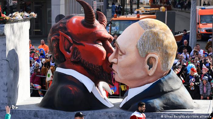 Ein Mottowagen beim Kölner Karneval zeigt Putin, der den Teufel küsst.