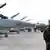 F-16 Kampfjets stehen aufgereiht auf einem Flugplatz, im Vordergrund ein NATO-Soldat (Foto: AP)